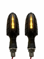 Two motorcycle turn signals with black textured casing and visible wiring on a white background.