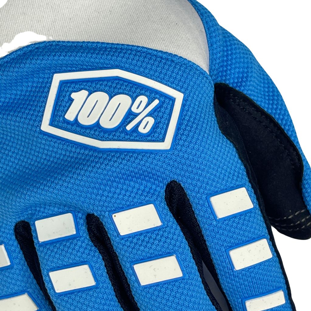 "Blue and white padded gloves with 100% logo, made from cloth material, featuring impact and palm padding, breathable design, adjustable closure, and touchscreen compatibility for track use."